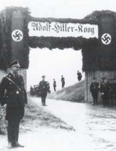 Männer der SS warten am 29.8.1935 an einer festlich geschmückten Stöpe auf die Ankunft Adolf Hitlers