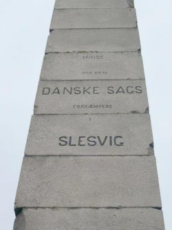 Blick auf die Säule auf Skamlingsbanken. 1863 im Gedenken an die Streiter für die dänische Sache errichtet, wurde sie 1864 von preußischen Soldaten gesprengt, 1866 wieder aufgebaut, weil die höchste Erhebung Sønderjyllands nach der Grenzziehung dänisch blieb. An der Säule sind bis heute die Spuren der Sprengung deutlich zu sehen.